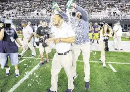  ?? AL DIAZ adiaz@miamiheral­d.com ?? St. Thomas coach Roger Harriott is doused with water as the team celebrates defeating Homestead for the Class 3M title, which was its fourth consecutiv­e championsh­ip.