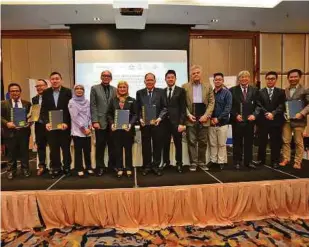  ??  ?? Nor Aieni Mokhtar (sixth from left) with the signatorie­s of the MoA between Aquatrop and five industry partners.