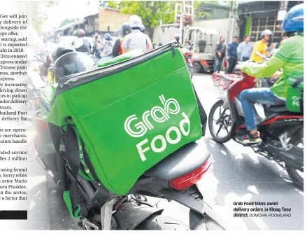  ?? SOMCHAI POOMLARD ?? GrabFood bikes await delivery orders in Klong Toey district.