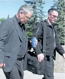  ?? BILL GRAVELAND/THE CANADIAN PRESS ?? Terry Megli, left, leaves Lethbridge court on Friday. Megli had testified at the triple murder trial of his grandson Derek Saretzky.