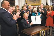  ?? Doug Mills / New York Times ?? President Trump signs an executive order that clears the way for potentiall­y sweeping changes in health insurance.