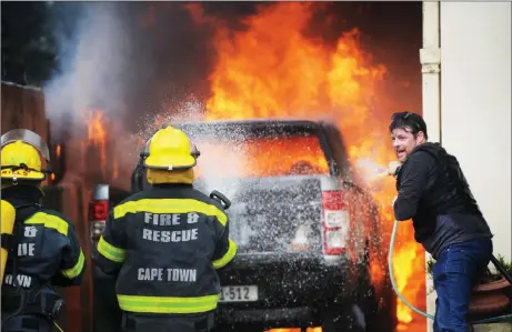  ?? Picture: Armand Hough/ African News Agency (ANA) ?? RUNNING BATTLE: Firefighte­rs at a torched vehicle, believed to belong to a fisheries official, after some Hangberg residents in Hout Bay took to the streets and protested yesterday. This was after it was alleged that a fisher, suspected of poaching, was shot by police.