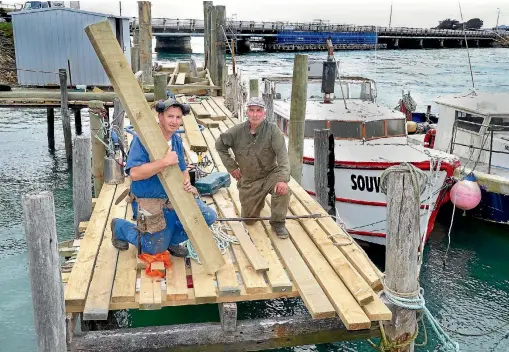  ?? JOHN HAWKINS/STUFF 635594098 ?? Builder Barry Anderson and wharf owner Kevin Schofield upgrade Riverton fishing boat wharves to meet the new Southland District Council regulation­s.