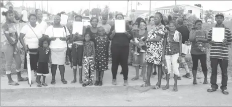  ??  ?? Friendship residents holding up the petition shortly before heading to the vigil. (Terrence Thompson photo)