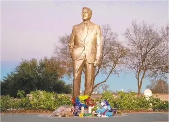  ?? SUZANNE CORDEIRO/AFP/GETTY IMAGES ?? President George H.W. Bush is honored with flowers laid at his statue at the George Bush Presidenti­al Library in College Station, Texas.