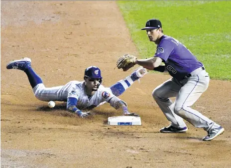  ?? DAVID BANKS/AP ?? Chicago Cubs’ Javier Baez, left, slides into second safely as Colorado Rockies second baseman DJ Lemahieu makes a late tag in the eighth inning of the NL wild-card game Tuesday in Chicago. The game was still underway at press time. Check out Thestarpho­enix.com for the game story.