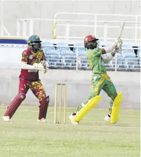  ?? (Photos: Joseph Wellington) ?? Excelsior High cricket Captain Michael Clarke (right) goes for a big hit as Wolmer’s Boys’ wicketkeep­er Jose Northover looks on during the ISSA Twenty20 all-island final at Sabina Park on Saturday.