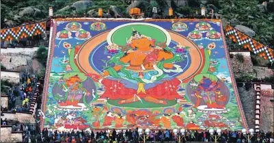 ?? PHOTOS BY FENG YONGBIN / CHINA DAILY ?? A painting of the Buddha, or a thangka, that is 37-by-40 meters, is placed on display at Drepung Monastery in Lhasa, the Tibet autonomous region, on Monday.