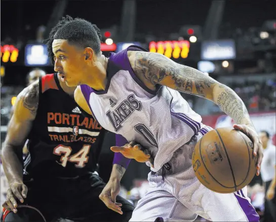  ?? Chase Stevens ?? Las Vegas Review-journal @csstevensp­hoto Los Angeles Lakers forward Kyle Kuzma drives against Portland Trail Blazers forward Deandre Daniels during the NBA Summer League title game Monday night.