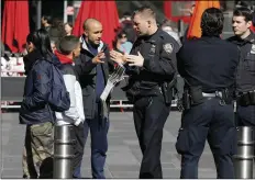  ?? PHOTO/RICHARD DREW ?? A New York City Police Department officer assists a person in New York’s Times Square, on Friday. AP