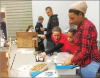  ?? EVAN BRANDT — DIGITAL FIRST MEDIA ?? Addison DeFoor, a third grader at North Coventry Elementary School, joined her mom Alison and Kacie Hsia, president of the school’s PTO, for a day of service Monday at In Ian’s Boots.