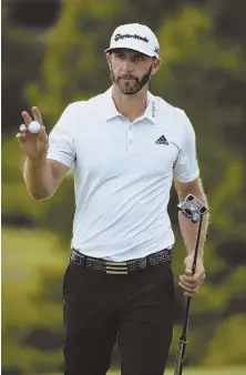  ?? AP PHOTO ?? PUTTER-ING ALONG: Dustin Johnson gestures toward fans after finishing the ninth hole during yesterday’s round of the St. Jude Classic in Memphis, Tenn.
