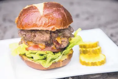  ?? JUNFU HAN/TNS ?? Wow your barbecue guests with award-winning pitmaster Bill Gillespie’s Jalapeño, Bacon and Cheddar-Stuffed Burger.