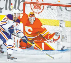  ?? Jeff Mcintosh The Associated Press ?? Oilers center Connor Mcdavid prepares to shoot against Flames goalie Jacob Markstrom in Edmonton’s 5-4 overtime win Thursday.