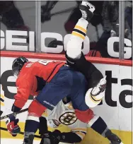  ?? Nick Wass / Associated Press ?? Washington Capitals defenseman Brenden Dillon (4) checks Boston Bruins center Curtis Lazar, back, during the third period on Tuesday.