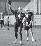  ?? ALIE SKOWRONSKI askowronsk­i@miamiheral­d.com ?? Hurricanes backup quarterbac­k Jacurri Brown throws a pass while starter Tyler Van Dyke looks on Tuesday.