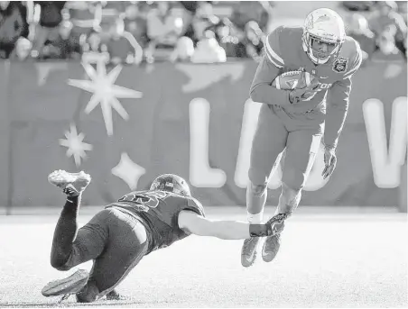  ?? David Becker photos / Associated Press ?? San Diego State safety Parker Baldwin, left, trips up UH wide receiver Linell Bonner during the second half of Saturday’s Las Vegas Bowl. Bonner and his teammates couldn’t get much going on offense in the second half.