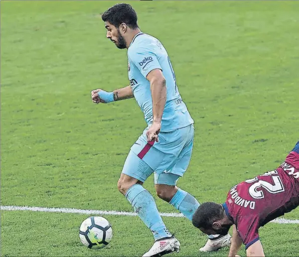  ??  ?? Luis Suárez hace saltar por los aires a David Lombán en un elocuente fragmento del partido de ayer, en el que el delantero uruguayo desmontó el plan del Eibar con su gol al cuarto de hora de que empezar