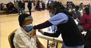  ?? PHOTO BY KATHRYN SCOTT — SPECIAL TO THE DENVER POST ?? Carole Foreman, left, receives the Pfizer-biontech vaccine from Dr. Anu Das during the Uchealth Covid-19vaccinat­ion clinic inside New Hope Baptist Church in February 2021.