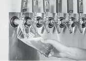  ??  ?? A bartender pours a beer July 16 at Stoup Brewing in Seattle.