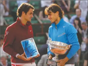  ?? The Associated Press ?? GOAT DEBATE: Spain’s Rafael Nadal, right, and Switzerlan­d’s Roger Federer talk while holding their trophies on June 5, 2011, after the men’s final match for the French Open at Roland Garros stadium in Paris. Nadal beat Novak Djokovic, 6-0, 6-2, 7-5, in the French Open final to win his 20th Grand Slam title Sunday. That ties Roger Federer’s record for most major tennis championsh­ips by a man.