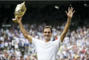  ?? DANIEL LEAL-OLIVAS — POOL PHOTO VIA AP ?? Roger Federer celebrates with the trophy after beating Marin Cilic in the Men’s Singles final match Sunday at Wimbledon.