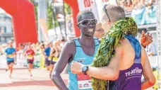  ??  ?? Der Zweite Isaac Kosgei (links) gratuliert dem Sieger.