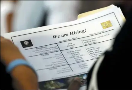  ?? THE ASSOCIATED PRESS ?? A job applicant looks at job listings for the Riverside Hotel at a job fair hosted by Job News South Florida, in Sunrise, Fla. The U.S. unemployme­nt rate fell to 3.7 percent in September 2018, the lowest level since December 1969 — signaling how the longest streak of hiring on record has put millions of Americans back to work.