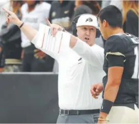  ?? David Zalubowski, The Associated Press ?? Colorado recruiting coordinato­r Darrin Chiaverini, pictured talking to sophomore quarterbac­k Steven Montez, recruited former Texas high school teammates KD Nixon and Laviska Shenault.