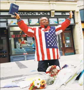  ?? Michael Dwyer / Associated Press ?? Cristopher Nzenwa prays at the site of the first explosion during the 2013 Boston Marathon on Sunday.