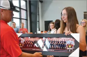  ?? Annette Beard/Pea Ridge TIMES ?? Sophomore Emory Bowlin, right, presented a photograph of the team as a gift to head coach Josh Reynolds, left, at the end of the Lady Blackhawks Softball Awards banquet Tuesday, May 30. For more photograph­s, go to the PRT gallery at https://tnebc.nwaonline. com/photos/.