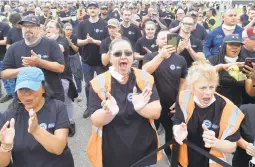  ?? DAVID RICHARD/AP ?? Ford Motor Co. workers react Thursday in Avon Lake, Ohio, to news that the automaker will be expanding the facility in order to build a new commercial electric vehicle.