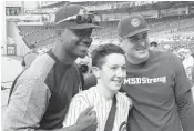  ?? CRAIG DAVIS/STAFF ?? Ben Wikander, 17, who was injured in the shootings at Stoneman-Douglas, shares a moment with Lewis Brinson, left, of the Marlins and Anthony Rizzo of the Cubs.