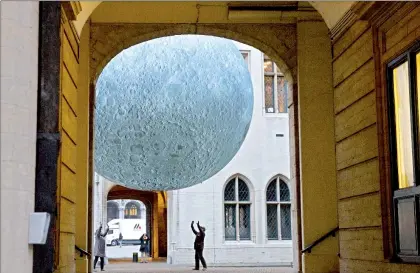  ??  ?? En el Museo de la Luna, en Bruselas, dos personas se acercan a la instalació­n artística que brinda por única vez la oportunida­d de contemplar el satélite natural en tres dimensione­s, suspendido en el centro del patio histórico ■ Foto Ap