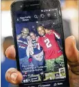  ?? ALYSSA POINTER / ALYSSA.POINTER@AJC.COM ?? Barber Maurice Combs (right) shows a photo of himself at a Super Bowl LI watch party in 2017. Despite leading 28-3, the Falcons lost to the Patriots in overtime.