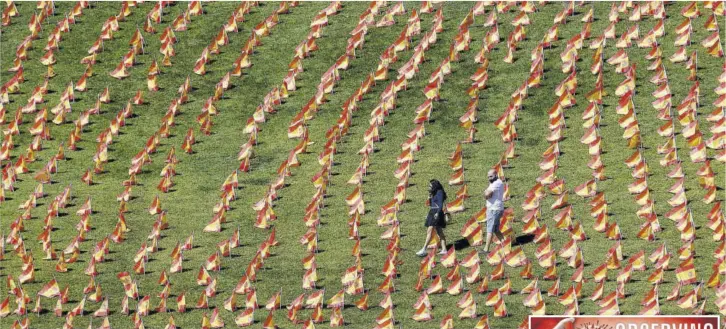  ?? (Photo: AFP) ?? MADRID, Spain — A couple walks among thousands of Spanish flags, representi­ng the Spanish victims of COVID-19, at the Roma park in Madrid, yesterday. Over the past week, Spain has registered the highest number of new cases within the EU with a rate of nearly 300 per 100,000 inhabitant­s — but in the Madrid region, the figure is currently more than 700 per 100,000. The global death toll has now passed one million.