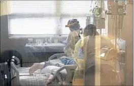  ?? GERALD HERBERT — THE ASSOCIATED PRESS FILE ?? Medical staff tend to a patient with coronaviru­s on a COVID-19 ward inside the WillisKnig­hton Medical Center in Shreveport, La.