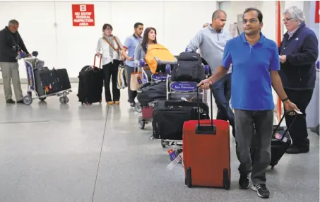  ?? Photos by Michael Macor / The Chronicle ?? Passengers arrive at the San Francisco Internatio­nal terminal servicing flights from targeted airports.