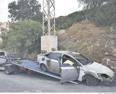  ?? FOTOS: JAVIER ALBIÑANA ?? La grúa retira uno de los coches incinerado­s.