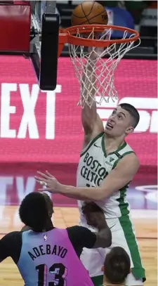  ?? Ap pHoTos ?? WINNER-WINNER: Celtics rookie guard Payton Pritchard throws in a putback bucket with 0.2 seconds on the clock to beat the Heat on Wednesday night in Miami. Below, Marcus Smart shoots over Tyler Herro.