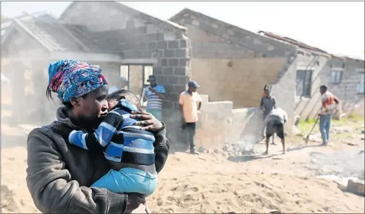  ?? Picture: JACKIE CLAUSEN ?? DEVASTATED: Dudu Chilli holds Mfanafuthi, 4, who was injured along with his brother, ‘Boy’, when the roof collapsed on their home. His mother, Mpume Chili and sister, Sbahle, were both killed