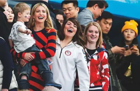  ?? AP ?? Ivanka Trump (left), daughter of US President Donald Trump, holds a child beside United States curler Becca Hamilton (centre) as they watch the men’s final curling match between the US and Sweden in Gangneung yesterday.