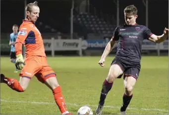  ??  ?? Wexford F.C. goalscorer Aaron Dobbs applying pressure on Cobh Ramblers netminder Paul Hunt.