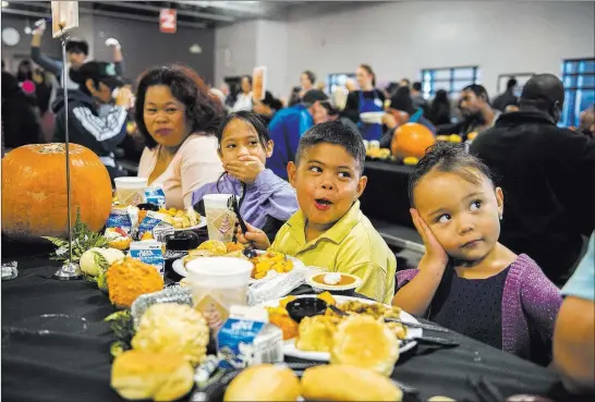  ?? Las Vegas Review-journal ?? Mary Rocha, left, and her children Jazmine, 8, Caesar, 7, and Marissa, 3, were among the hundreds of diners at Catholic Charities’ annual Thanksgivi­ng meal in 2015.