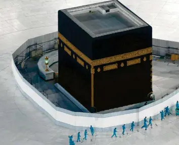  ?? Foto: Amr Nabil, dpa ?? Arbeiter desinfizie­ren den Boden um die Kaaba, das quaderförm­ige Gebäude in der Großen Moschee von Mekka. Zuletzt wurde die Pilgerfahr­t Mitte des 19. Jahrhunder­ts abgesagt.