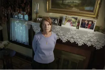  ?? PHOTOS BY ROBERT BUMSTED — THE ASSOCIATED PRESS ?? Margot Eckert stands by a display of pictures of her brother-in-law Sean Rooney and sister Beverly Eckert at her home, Thursday in Springfiel­d, Mass. Rooney was killed on Sept. 11while working in his office in the South Tower. His wife, Beverly, died in a plane crash in 2009. The collection of some 22,000persona­l artifacts — some on display at the 9/11 museum, and others on display at other museums around the country — provide a mosaic of lost lives and stories of survival: wallets, passports, baseball gloves, shoes, clothes and rings.