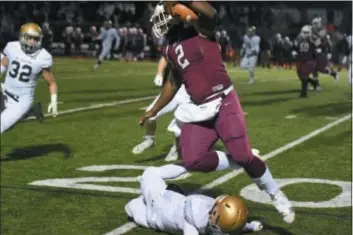  ?? MICHAEL REEVES — FOR DIGITAL FIRST MEDIA ?? Penn Wood quarterbac­k Desman Johnson powers over and through Rustin’s defense on a run Saturday night in the District 1 Class 5A semifinal game. Johnson had an uncharacte­ristic two fumbles and a pick, but also became the passing yardage leader in Delco football history.