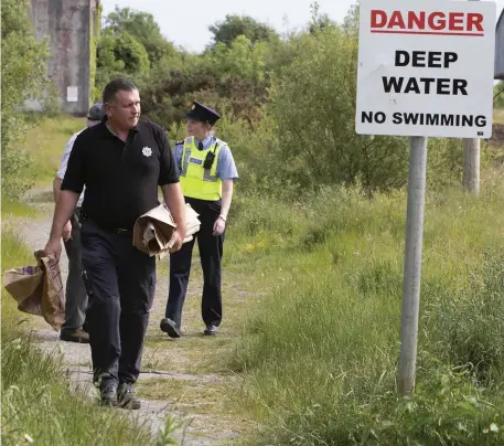  ??  ?? Gardaí examine the scene of the double drowning at an abandoned quarry near Ennis yesterday. Photo: Pat Flynn