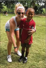  ??  ?? Colleen Williams, giving a Thai boy cleats, was inspired by the charitable work, calling it “the best feeling ever.”