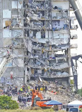  ?? AP PHOTO/MARK HUMPHREY ?? Search and rescue personnel work atop the rubble at the Champlain Towers South condo building on Friday, July 2, in Surfside, Fla. The rest of the building was demolished two days later to help in the rescue and recovery effort.